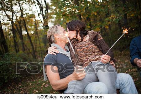 Stock Photograph - Mature couple kissing with sparklers. Fotosearch