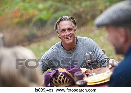 Stock Photograph - Mature man at outdoor dinner. Fotosearch