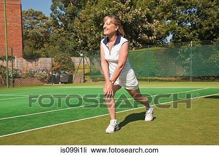 Mature woman performing warming up exercises on tennis court View Large Photo Image Stock Image - Mature woman performing warming up exercises on tennis court. Fotosearch