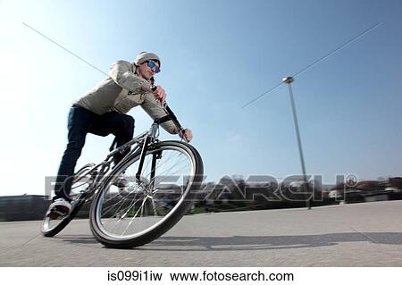 Mid adult cyclist riding bike View Large Photo Image Stock Photo - Mid adult cyclist riding bike. Fotosearch