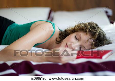 Stock Photograph - Mid adult woman sleeping in bedroom. Fotosearch