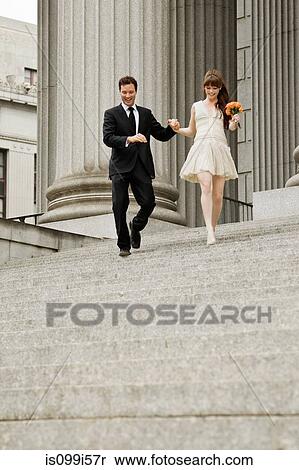 Stock Photography - Newlywed couple descending steps together. Fotosearch