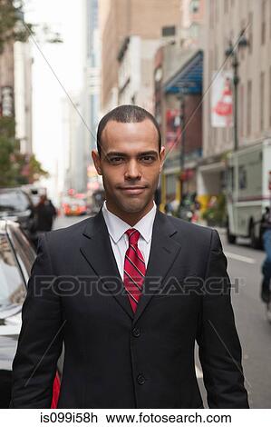 Stock Image - Portrait of businessman in city. Fotosearch