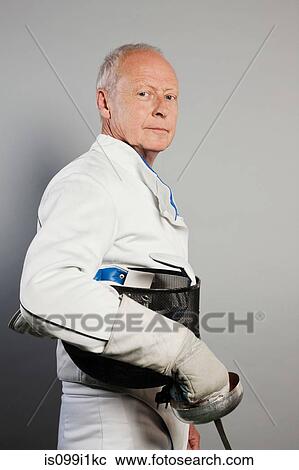 Stock Image - Portrait of senior man in fencing suit. Fotosearch