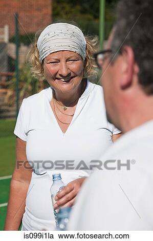 Senior and mature adults enjoying drink on tennis court View Large Photo Image Stock Image - Senior and mature adults enjoying drink on tennis court. Fotosearch