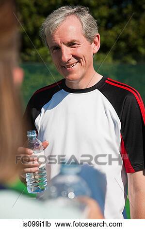 Senior and mature adults enjoying drink on tennis court View Large Photo Image Stock Image - Senior and mature adults enjoying drink on tennis court. Fotosearch