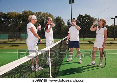 Senior and mature adults enjoying drink on tennis court View Large Photo Image Stock Photo - Senior and mature adults enjoying drink on tennis court. Fotosearch