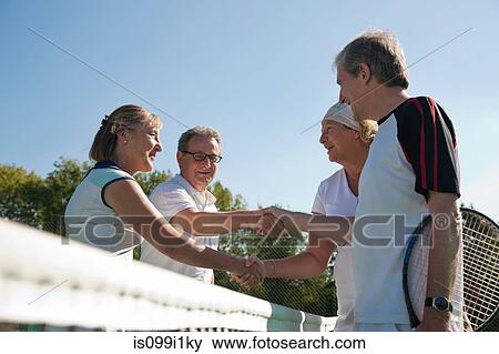 Senior and mature adults shaking hands on tennis court View Large Photo Image Stock Photo - Senior and mature adults shaking hands on tennis court. Fotosearch