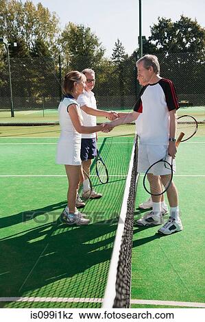 Senior and mature adults shaking hands on tennis court View Large Photo Image Stock Photo - Senior and mature adults shaking hands on tennis court. Fotosearch