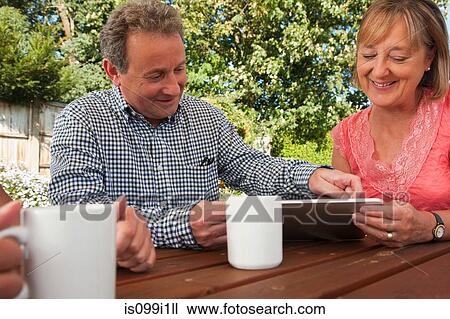 Senior couple looking at digital tablet outdoors View Large Photo Image Stock Image - Senior couple looking at digital tablet outdoors. Fotosearch