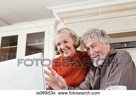 Senior couple using webcam on laptop View Large Photo Image Stock Photo - Senior couple using webcam on laptop. Fotosearch
