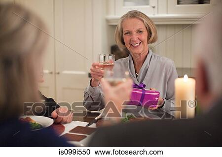 Senior woman at dinner party with gift View Large Photo Image Stock Image - Senior woman at dinner party with gift. Fotosearch