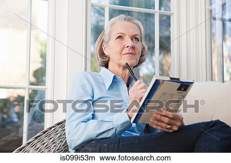 Picture - Senior woman doing sudoku puzzles. Fotosearch