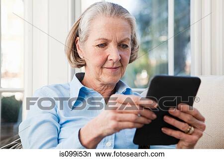 Senior woman reading electronic book View Large Photo Image Picture - Senior woman reading electronic book. Fotosearch