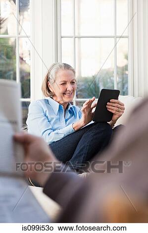 Senior woman using electronic book View Large Photo Image Picture - Senior woman using electronic book. Fotosearch