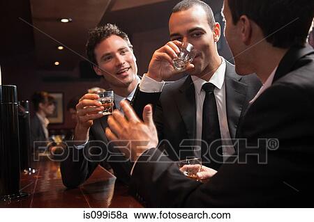 Three businessmen drinking at a bar View Large Photo Image Stock Image - Three businessmen drinking at a bar. Fotosearch