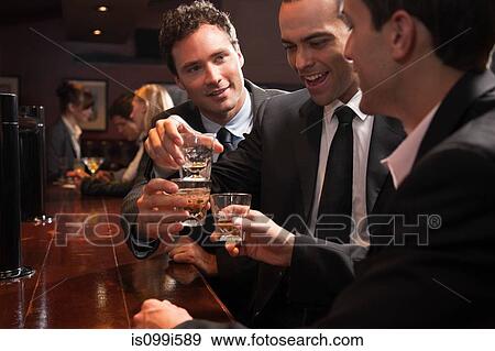 Three businessmen drinking at a bar View Large Photo Image Stock Photo - Three businessmen drinking at a bar. Fotosearch