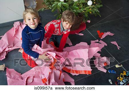 Two boys unwrapping Christmas presents, portrait View Large Photo Image Stock Image - Two boys unwrapping Christmas presents, portrait. Fotosearch
