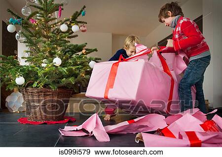 Two boys unwrapping Christmas presents View Large Photo Image Stock Photo - Two boys unwrapping Christmas presents. Fotosearch