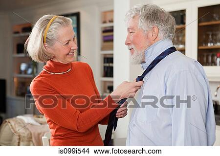 Picture - Wife tying tie for husband. Fotosearch