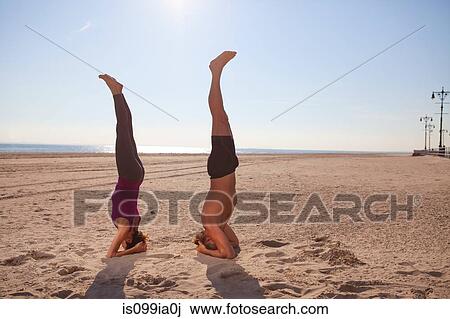 Woman and man performing handstands on beach View Large Photo Image Stock Image - Woman and man performing handstands on beach. Fotosearch
