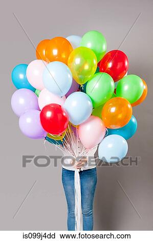 Woman holding large amount of balloons View Large Photo Image Stock Image - Woman holding large amount of balloons. Fotosearch