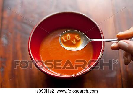 Woman holding spoonful of soup with letters LOVE View Large Photo Image Stock Image - Woman holding spoonful of soup with letters LOVE. Fotosearch
