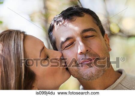 Woman kissing man on cheek View Large Photo Image Stock Photograph - Woman kissing man on cheek. Fotosearch