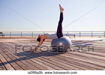 Woman stretching on exercise ball on promenade View Large Photo Image Stock Image - Woman stretching on exercise ball on promenade. Fotosearch