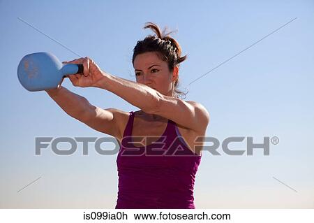 Woman working out with kettlebell View Large Photo Image Stock Image - Woman working out with kettlebell. Fotosearch