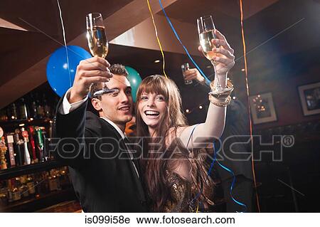 Stock Image - Young couple celebrating with champagne. Fotosearch