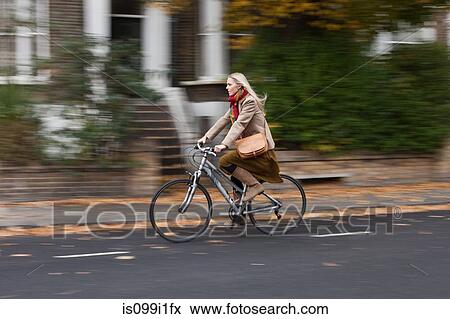 Young woman cycling on road View Large Photo Image Stock Photo - Young woman cycling on road. Fotosearch