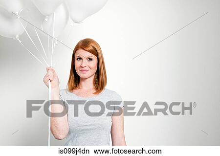 Young woman holding balloons View Large Photo Image Picture - Young woman holding balloons. Fotosearch