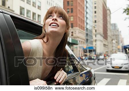 Young woman leaning out of taxicab window, looking up View Large Photo Image Picture - Young woman leaning out of taxicab window, looking up. Fotosearch
