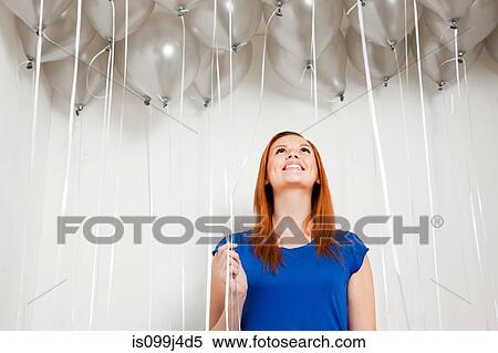 Young woman looking up at balloons View Large Photo Image Stock Photography - Young woman looking up at balloons. Fotosearch