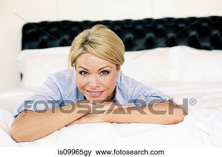Blond woman lying on bed View Large Photo Image Stock Photo - Blond woman lying on bed. Fotosearch
