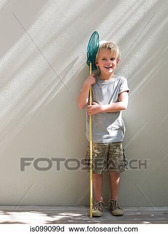 Boy standing by wall with fishing net, portrait View Large Photo Image Stock Image - Boy standing by wall with fishing net, portrait. Fotosearch