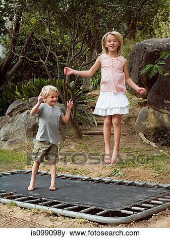 Brother and sister bouncing on trampoline View Large Photo Image Stock Photo - Brother and sister bouncing on trampoline. Fotosearch