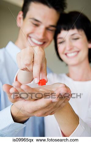 Couple holding model house View Large Photo Image Stock Photo - Couple holding model house. Fotosearch
