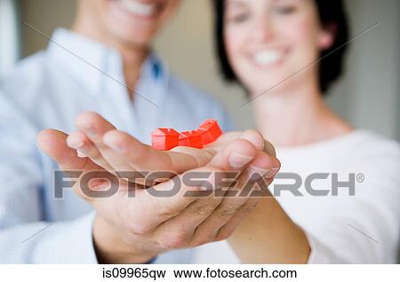 Stock Photo - Couple holding model houses. Fotosearch