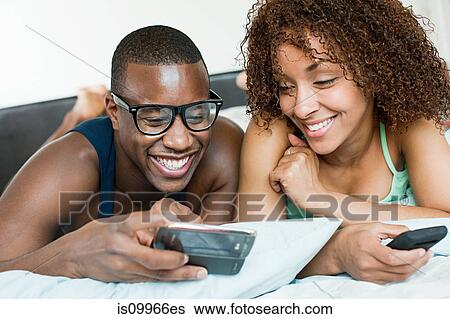 Stock Photograph - Couple looking at smartphones. Fotosearch