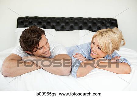 Couple lying on bed, portrait View Large Photo Image Stock Photograph - Couple lying on bed, portrait. Fotosearch
