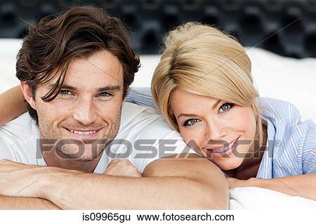Couple lying on bed, portrait View Large Photo Image Stock Photograph - Couple lying on bed, portrait. Fotosearch