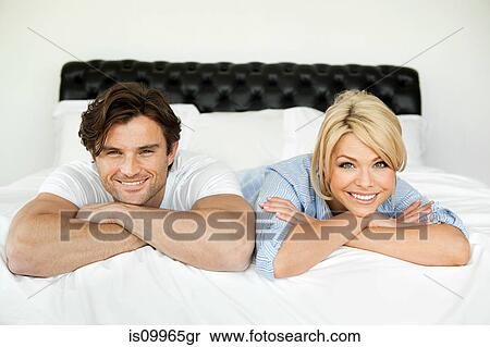 Couple lying on bed, portrait View Large Photo Image Stock Photography - Couple lying on bed, portrait. Fotosearch