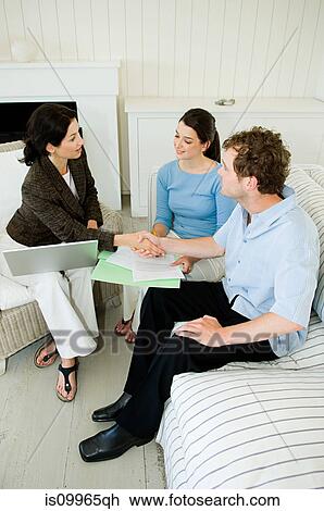 Stock Image - Couple meeting financial advisor at home. Fotosearch