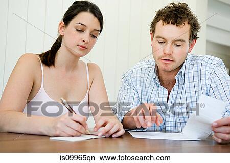 Couple planning home finances, woman writing cheque View Large Photo Image Picture - Couple planning home finances, woman writing cheque. Fotosearch