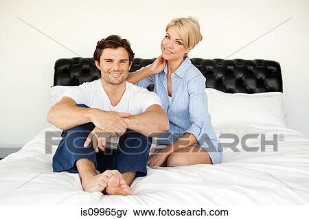 Couple sitting on bed, portrait View Large Photo Image Stock Photo - Couple sitting on bed, portrait. Fotosearch