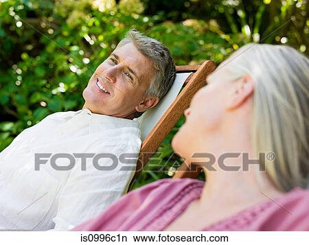 Picture - Couple sitting on deckchairs in garden. Fotosearch
