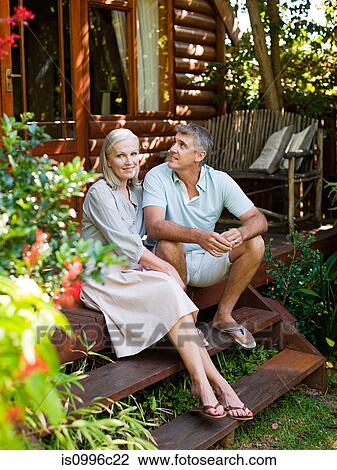 Couple sitting on porch steps in garden View Large Photo Image Stock Image - Couple sitting on porch steps in garden. Fotosearch