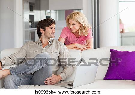 Picture - Couple using laptop at home. Fotosearch
